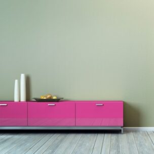 Modern living room with a pink TV stand against a green wall.